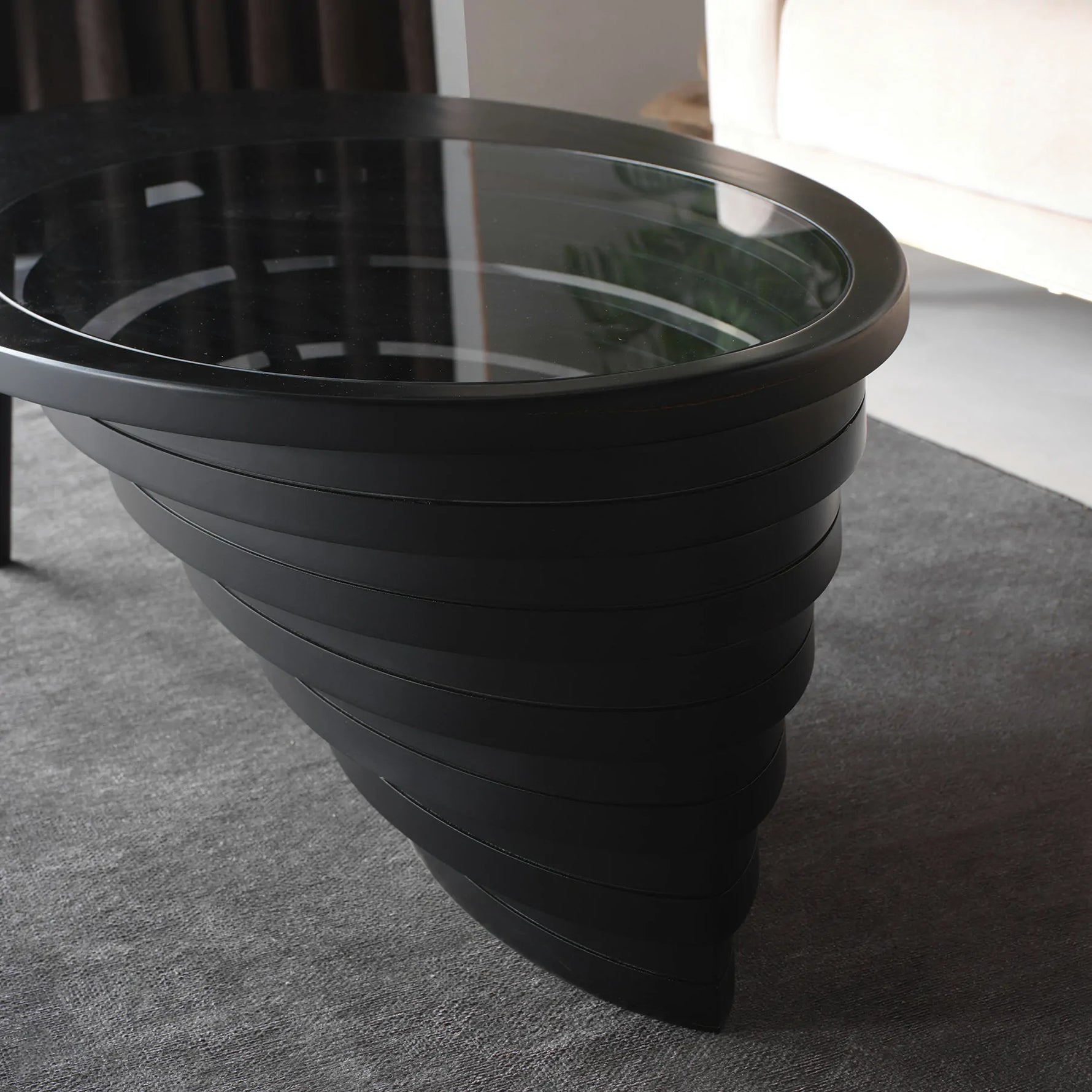 Statement furniture piece with carved wood and smooth glass