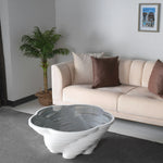 White sculptural coffee table with vortex-shaped base